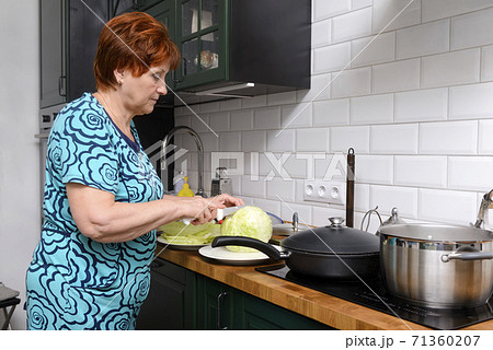 adult white woman cooks food in the kitchen 71360207