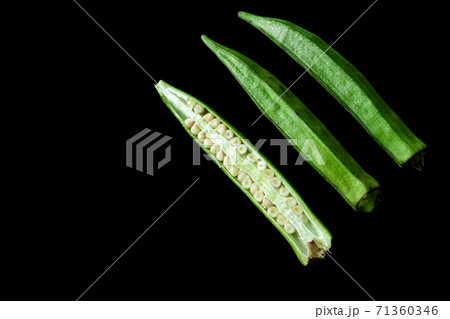 Green tropical vegetable called ladies' fingers or ochro on black background Green tropical vegetable called ladies' fingers or ochro on black background 71360346