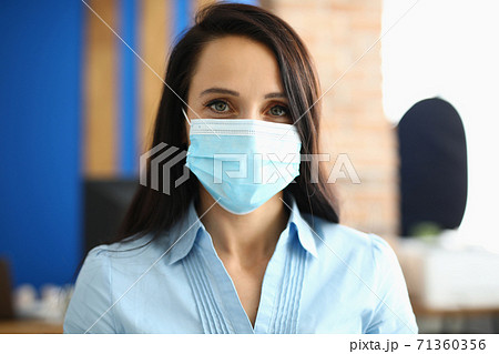 Portrait of businesswoman in protective medical mask in office 71360356