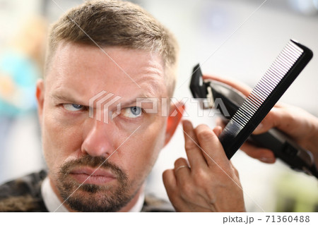 Portrait of pensive man who has haircut in hairdressing machine. Portrait of pensive man who has haircut in hairdressing machine. 71360488