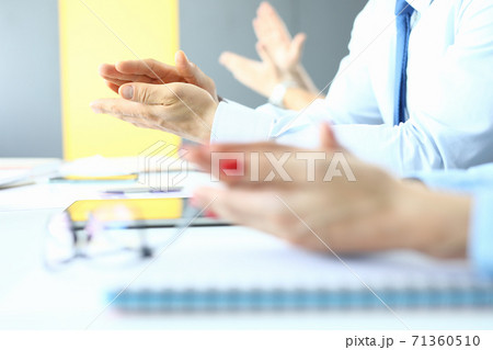 Womens and mens applaud at work table in office. 71360510