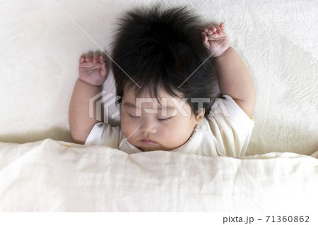 布団をかぶって寝ている赤ちゃんの顔、0歳、生後4か月、女の子 71360862