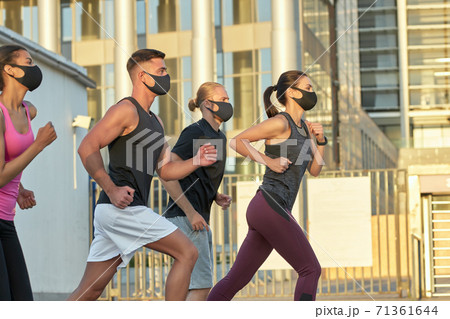 Young mixed race team in protective masks training outdoors 71361644