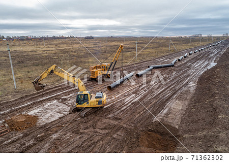 laying the pipeline with an excavator. Autumn, shooting from a drone. Earthworks, infrastructure construction 71362302