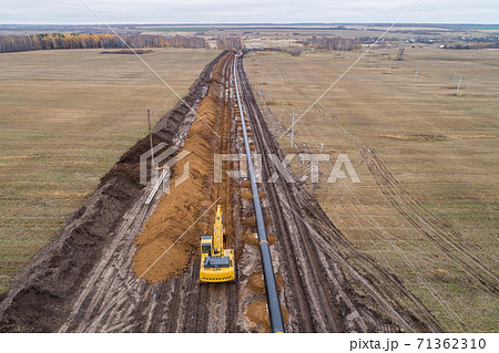 laying the pipeline with an excavator. Autumn, shooting from a drone. Earthworks, infrastructure construction 71362310