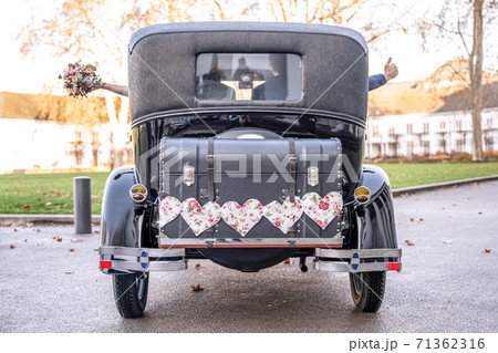 Wedding Couple in Oldtimer Ford Typ A Tudor Sedan 1928 during a Wedding Decorated Wedding Couple in Oldtimer Ford Typ A Tudor Sedan 1928 during a Wedding Decorated 71362316