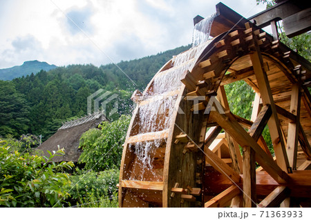 The mill wheel rotates under a stream of water. The mill wheel rotates under a stream of water. 71363933