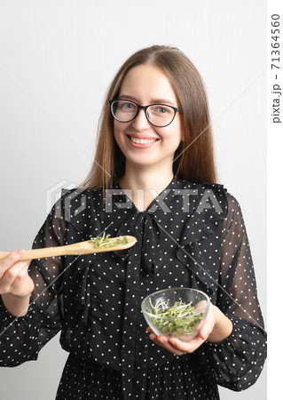 Caucasian young beautiful woman with microgreens salad superfood, healthy lifestyle 71364560