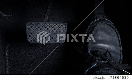 Close up images of man driving car by pushing accelerator and brake pedal with right foot black leather shoe and black jean pant. camera shot inside the japanese car. 71364659