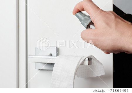 Cleaning door handle with spray 71365492