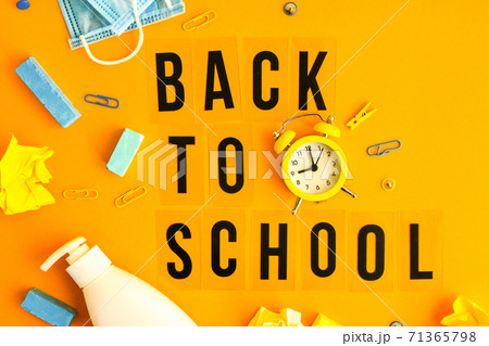 Text BACK TO SCHOOL on yellow background with school supplies, protective face mask and sanitizer antiseptic. New normal. School quarantine concept. Copy space Text BACK TO SCHOOL on yellow background with school supplies, protective face mask and sanitizer antiseptic. New normal. School quarantine concept. Copy space 71365798