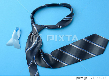 silk blue mens tie and ribbon folded in a loop on blue background 71365978