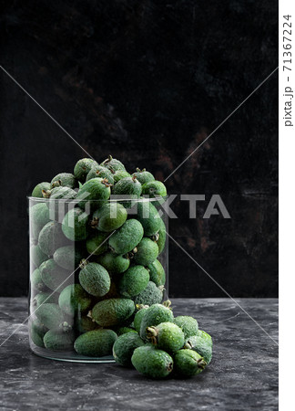 green feijoa fruit in glass vase on a black background green feijoa fruit in glass vase on a black background 71367224
