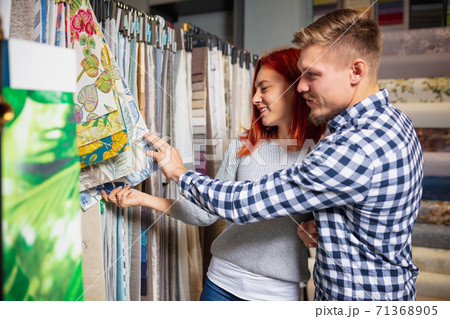 Couple choosing textile at home decoration store, shop. Making of home interior design during quarantine Couple choosing textile at home decoration store, shop. Making of home interior design during quarantine 71368905