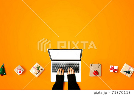 Person using a laptop computer with Christmas gift boxes Person using a laptop computer with Christmas gift boxes 71370113