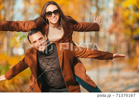 Happy family walking in autumn park on sunny fall day Happy family walking in autumn park on sunny fall day 71370167