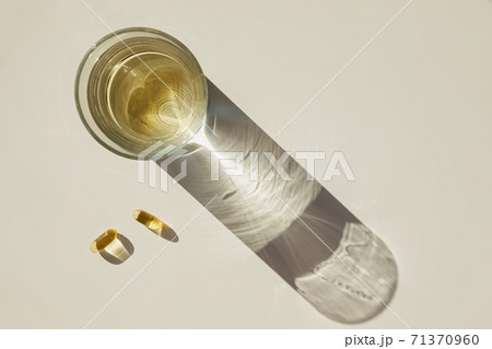 Glass of water and fish oil isolated on white background Glass of water and fish oil isolated on white background 71370960