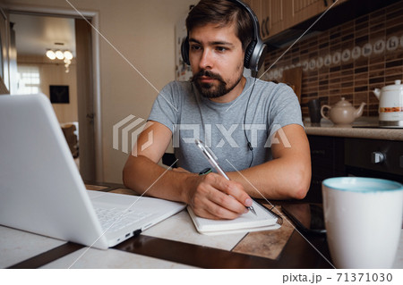 Focused young man wear headphones study online Focused young man wear headphones study online 71371030