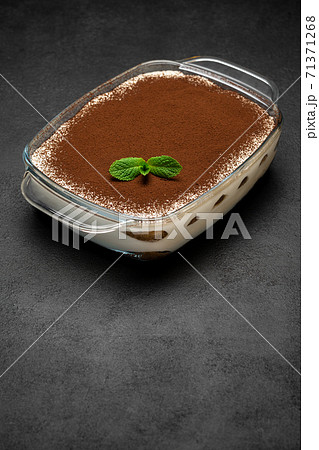 Traditional Italian Tiramisu dessert in glass baking dish on concrete background 71371268