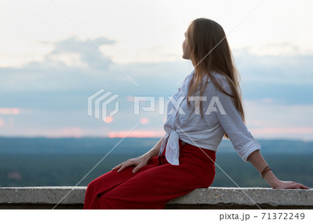 Portrait of young woman against sky background. Girl thinks and looks into the distance Portrait of young woman against sky background. Girl thinks and looks into the distance 71372249