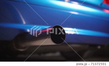 Close-up of the exhaust pipe of a tuned sports car. Part symbol and conceptual tuning, motorsport, workshops, background. Vehicle standing on an asphalt road on a clear weather. Close-up of the exhaust pipe of a tuned sports car. Part symbol and conceptual tuning, motorsport, workshops, background. Vehicle standing on an asphalt road on a clear weather. 71372501