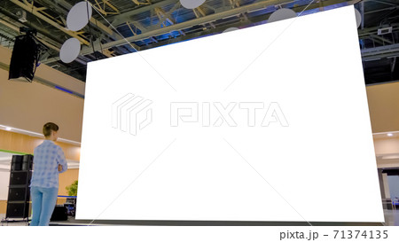 Woman looking at blank large interactive wall display - white screen concept Woman looking at blank large interactive wall display - white screen concept 71374135