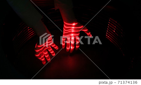 Optical illusion with red lasers and woman hands Optical illusion with red lasers and woman hands 71374136