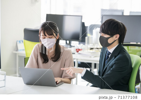 マスクをしてオフィスで働く20代の日本人 71377108