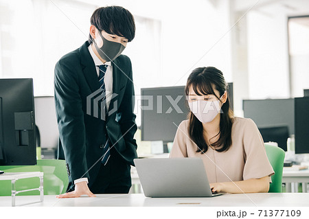 マスクをしてオフィスで働く20代の日本人 71377109