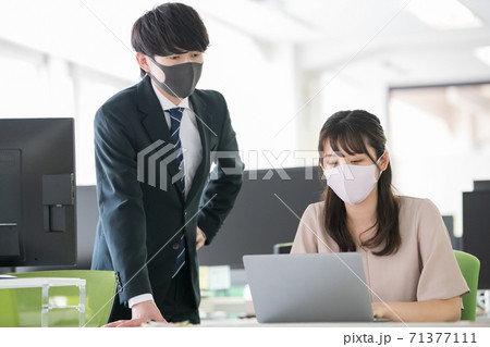 マスクをしてオフィスで働く20代の日本人 71377111
