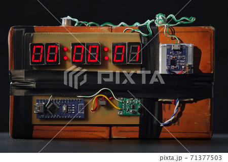 Bomb with red timer on black background. Improvised explosive device. Terrorist threat. Dynamite with clockwork. Explosives with detonator. Time bomb is going to explode or detonate per 1 second. TNT 71377503