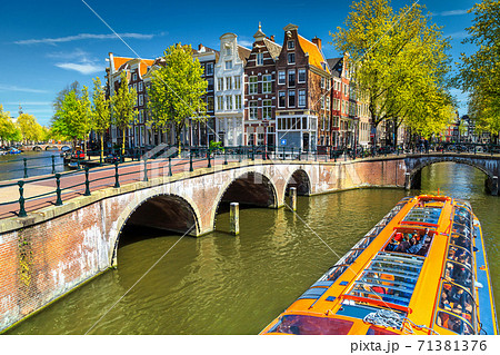 Typical Amsterdam canals with bridges and colorful boat, Netherlands, Europe 71381376