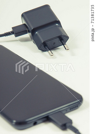 Smartphone with connected plug of charger. Telephone charging Smartphone with connected plug of charger. Telephone charging 71381735