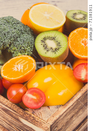 Fresh fruits with vegetables in rustic box as food containing healthy minerals and vitamins Fresh fruits with vegetables in rustic box as food containing healthy minerals and vitamins 71381911