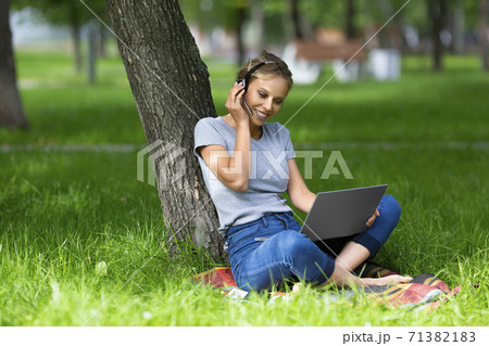 Young student-girl during online lesson in campus park. Young student-girl during online lesson in campus park. 71382183