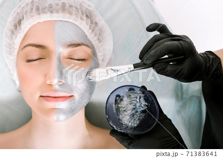medical procedure. The process of applying a beauty mask to the skin of a patient with her eyes closed lying on a pillow. the concept protection and retardation against ageing and skin care medical procedure. The process of applying a beauty mask to the skin of a patient with her eyes closed lying on a pillow. the concept protection and retardation against ageing and skin care 71383641