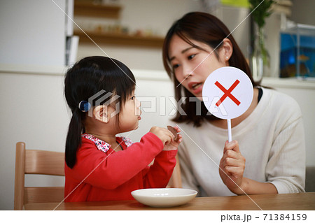 ×の札を持つ母親 71384159
