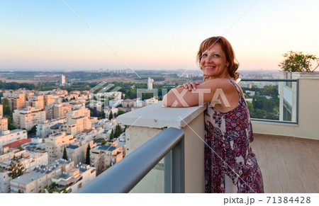 Woman on a balcony in downtown 71384428