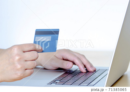 A Person online shopping with a credit card and a laptop. A Person online shopping with a credit card and a laptop. 71385065