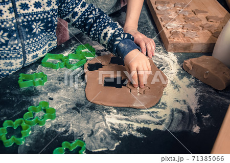 Happy loving family in the kitchen before Christmas. Mother and child preparing the dough, bake ginger cookies Happy loving family in the kitchen before Christmas. Mother and child preparing the dough, bake ginger cookies 71385066