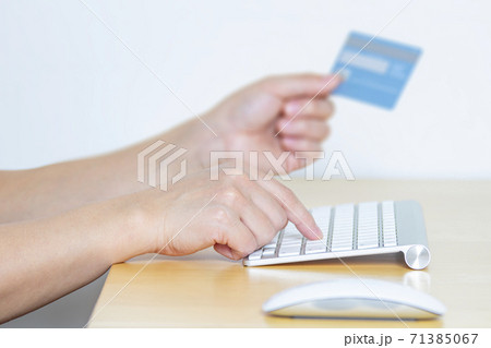 A Person online shopping with a credit card and a computer A Person online shopping with a credit card and a computer 71385067