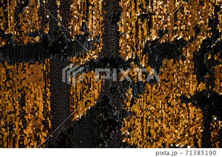 Reversible iridescent sequin fabric. Black and gold abstract glitter background. Festive double sided chameleon textile Reversible iridescent sequin fabric. Black and gold abstract glitter background. Festive double sided chameleon textile 71385190