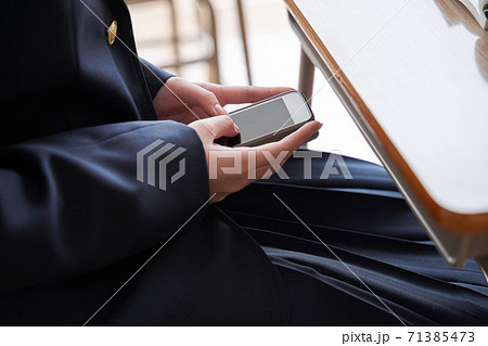 教室で隠れてスマホを操作する日本人女子中学生 教室で隠れてスマホを操作する日本人女子中学生 71385473