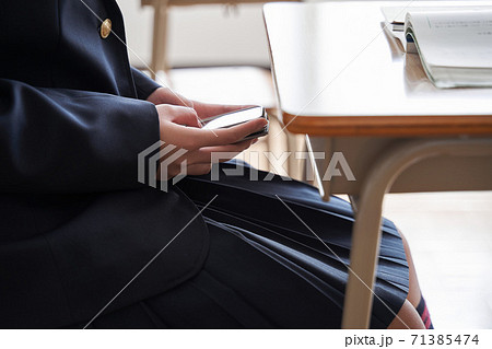 教室で隠れてスマホを操作する日本人女子中学生 教室で隠れてスマホを操作する日本人女子中学生 71385474