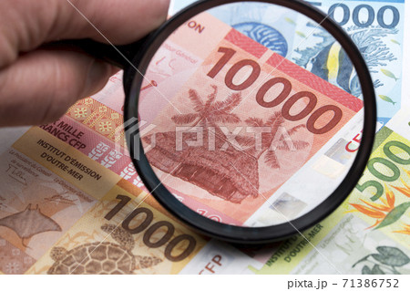 French Pacific Territories Francs in a magnifying glass French Pacific Territories Francs in a magnifying glass 71386752