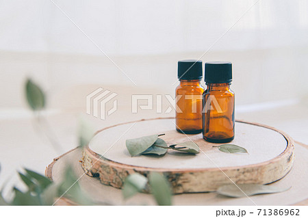 木とアロマオイルビンが2本。自然・オーガニック・美容のイメージ。 71386962
