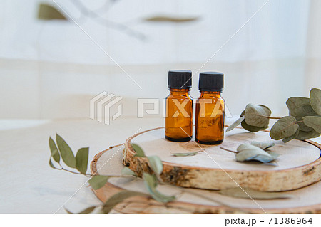 木とアロマオイルビンが2本。自然・オーガニック・美容のイメージ。 71386964