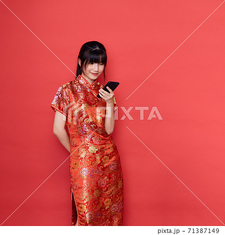 Cute Asian woman wear Chinese dress use a smart mobile phone Cute Asian woman wear Chinese dress use a smart mobile phone 71387149