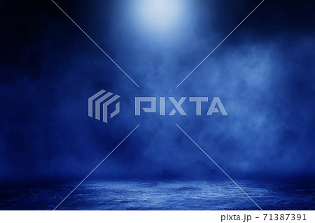 Studio dark room concrete floor grunge texture background with blue lighting effect and smoke in background. 71387391