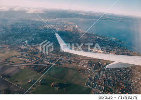 Airplane interior with window view of the Baltic sea and clouds. Airplane interior with window view of the Baltic sea and clouds. 71388278